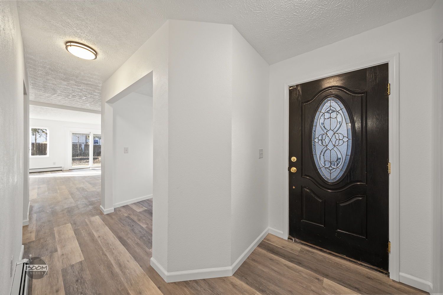 Entry hallway with a new front door and wide-plank flooring