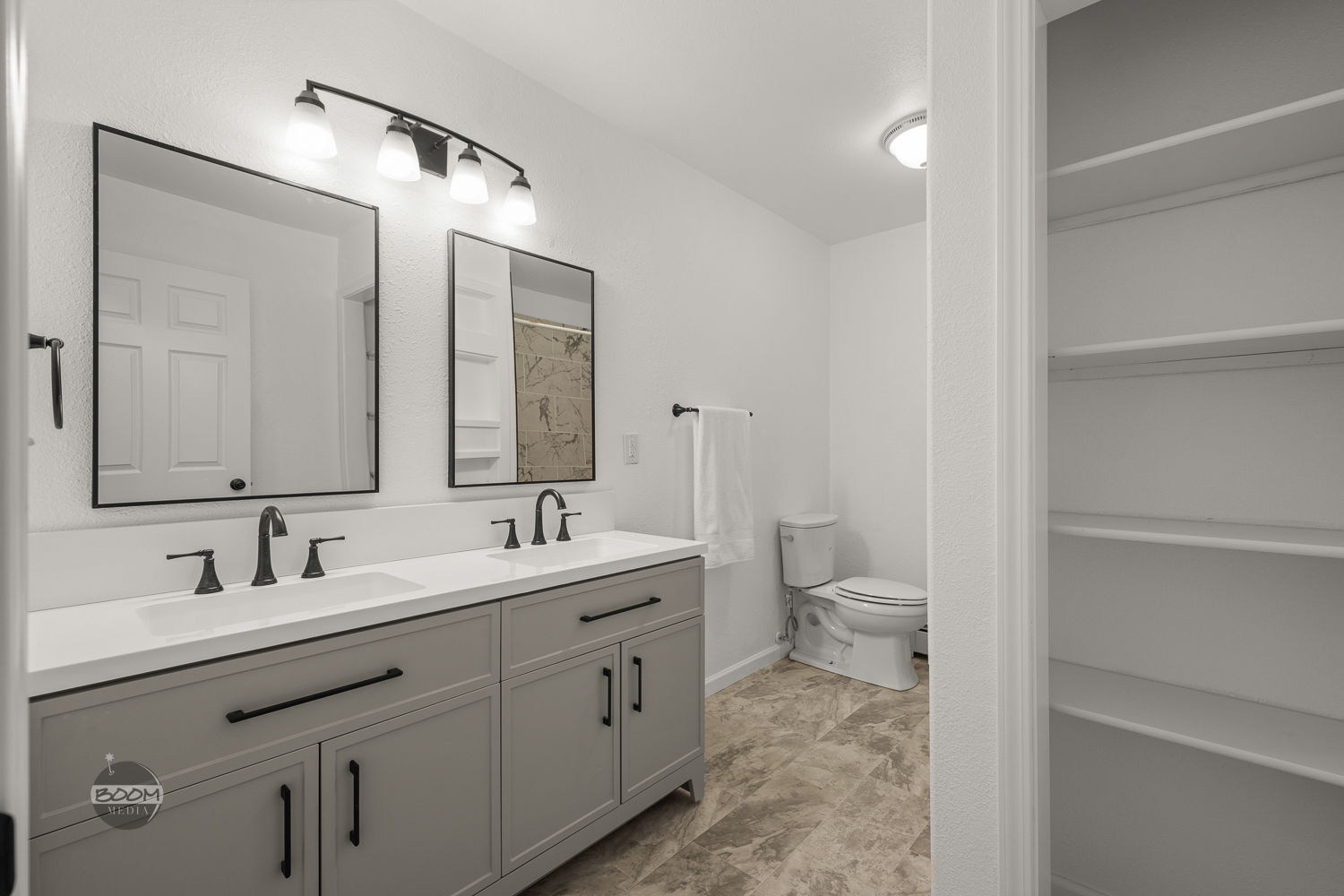 Double-vanity bathroom with gray cabinetry and framed mirrors