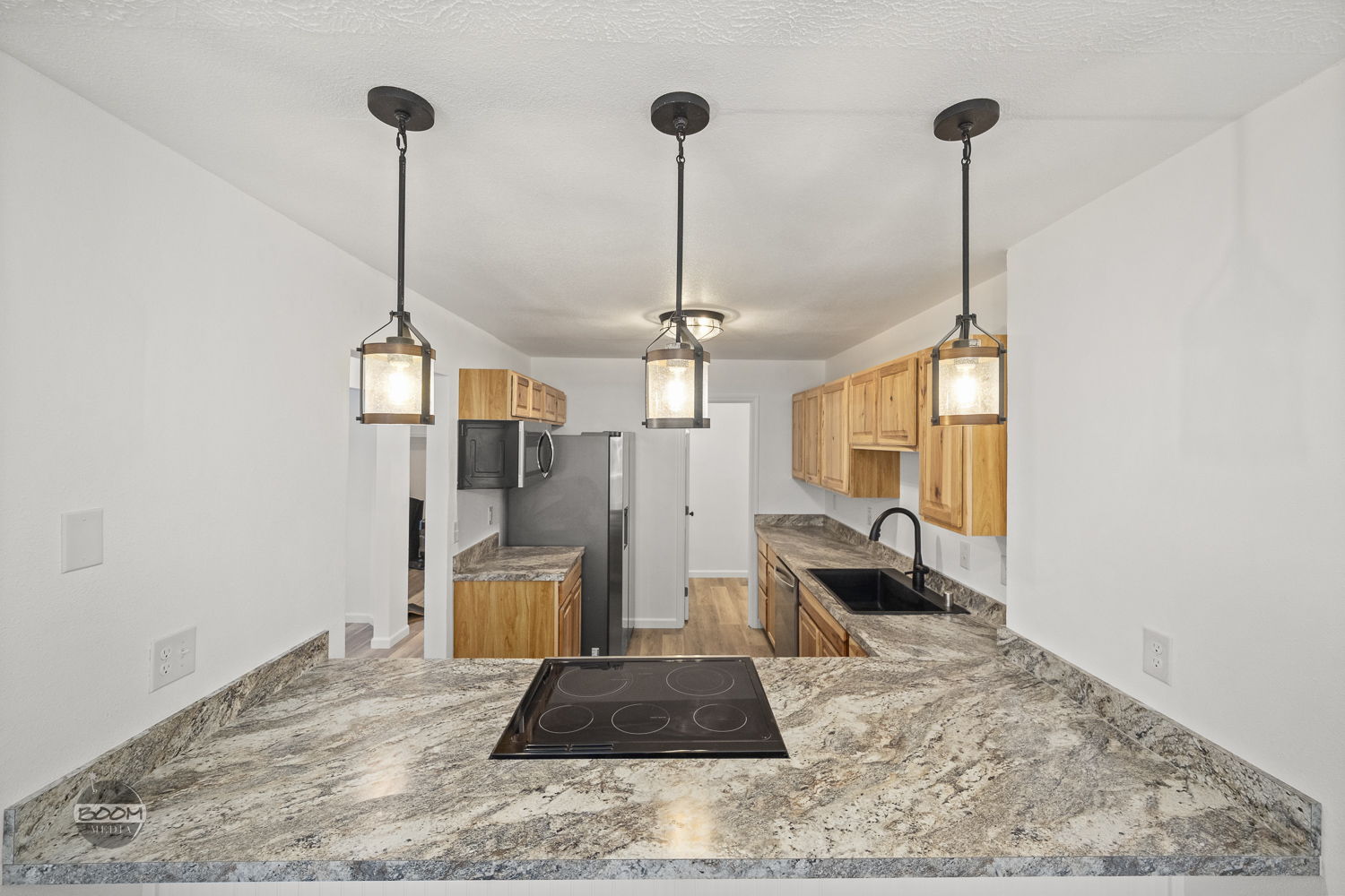 New kitchen island with granite counters and pendant lighting