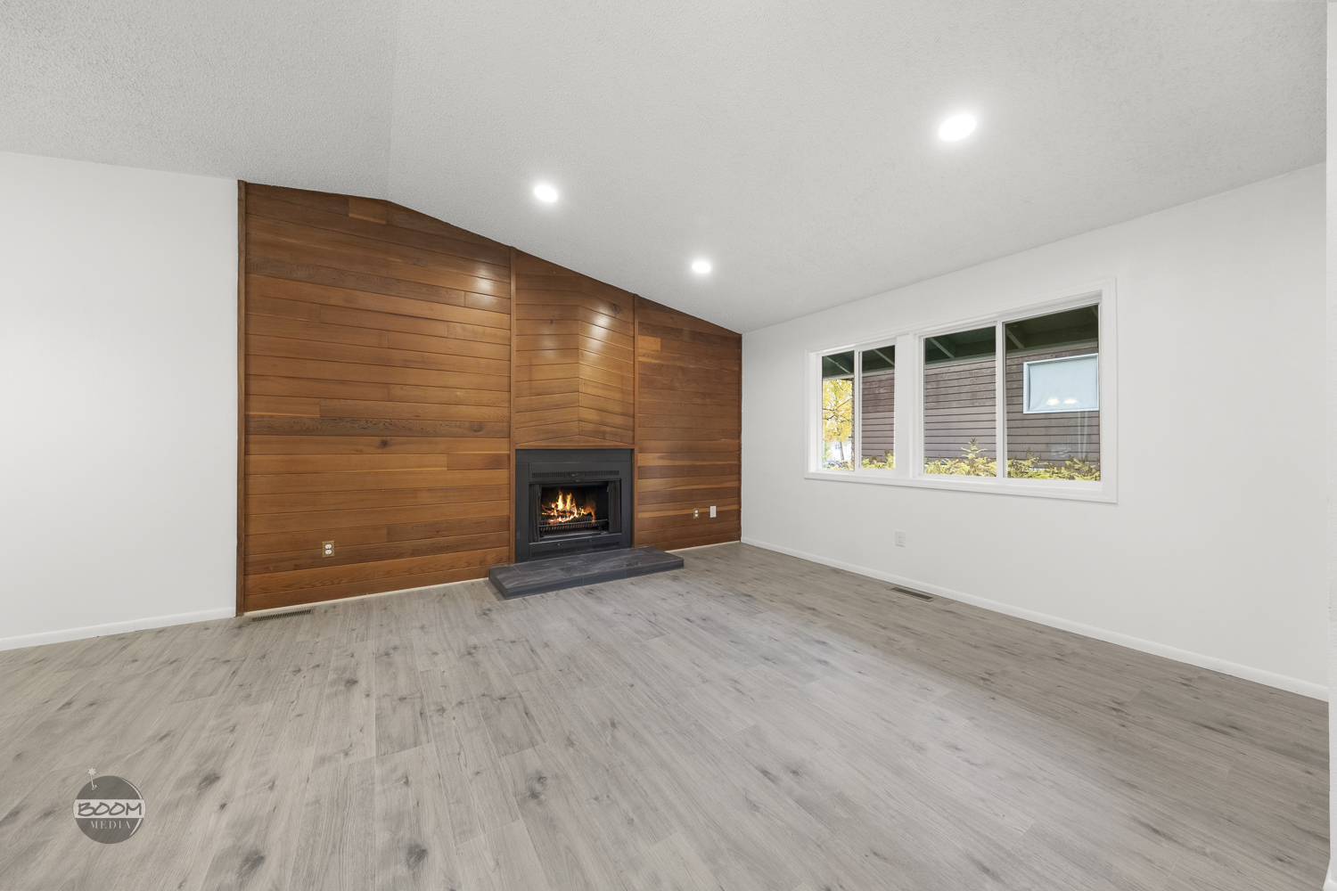 Living room with a cedar accent wall and a fireplace insert