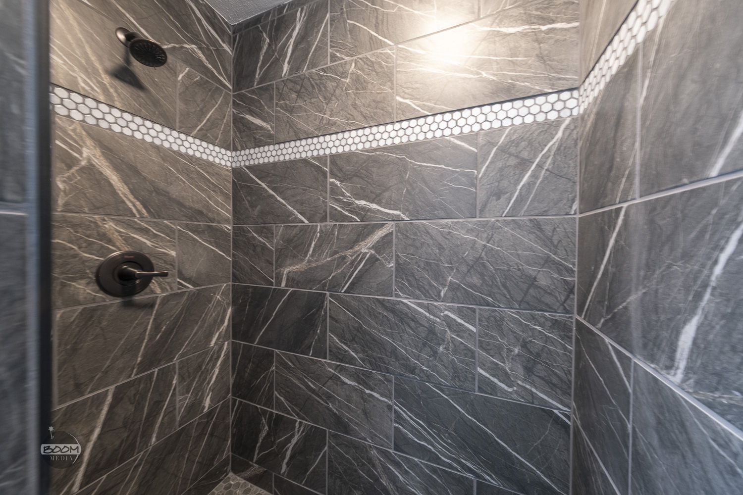 Tiled walk-in shower with a mosaic accent band