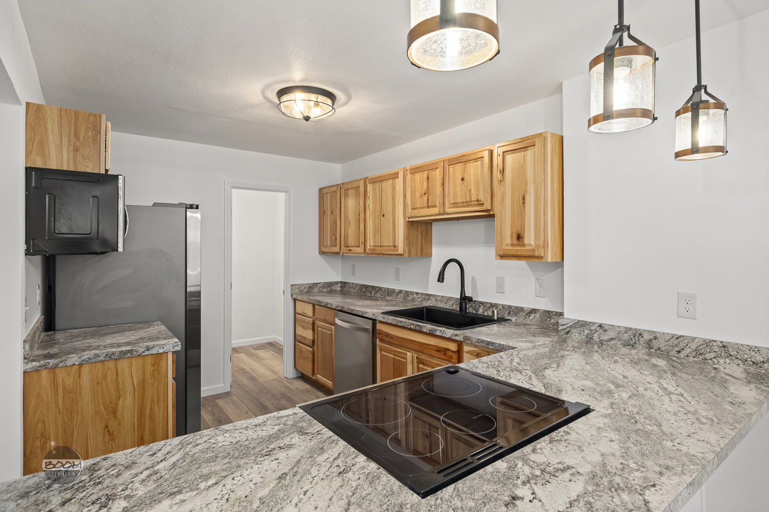 Remodeled kitchen with hickory cabinets, granite counters and a black composite sink