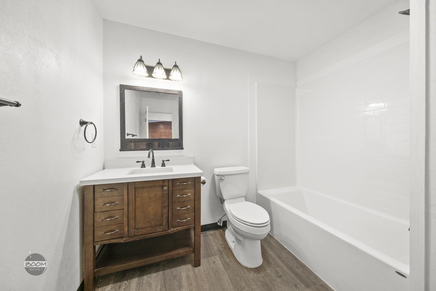 Refinished bathroom with a wood vanity and new lighting