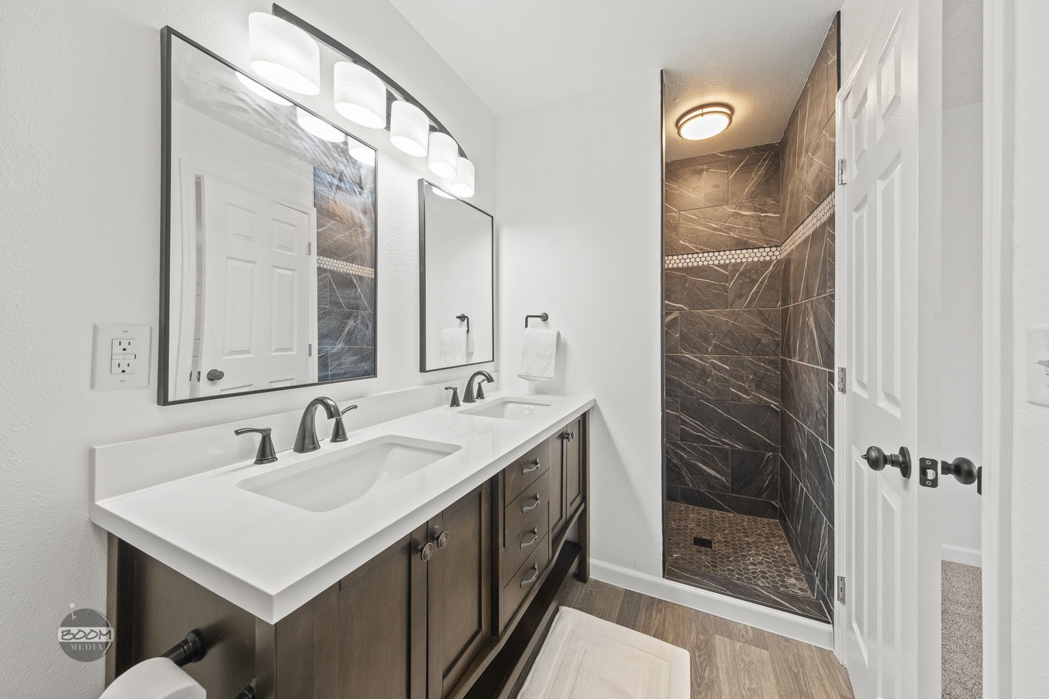 Double vanity beside a tiled walk-in shower