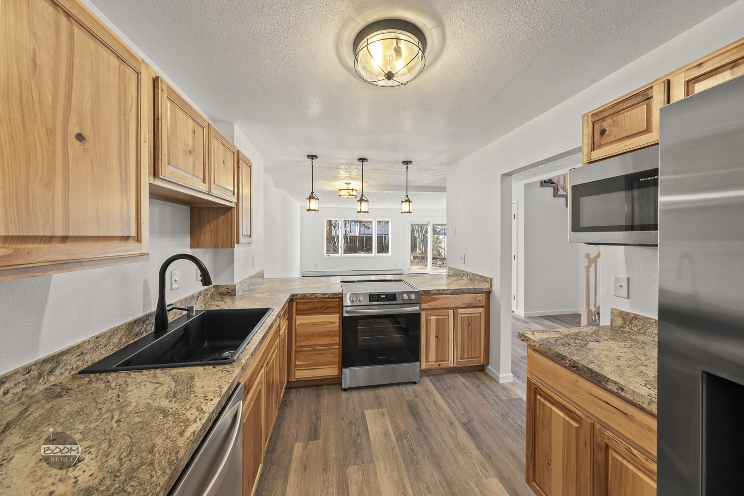 Renovated kitchen with hickory cabinets, granite counters and a black sink