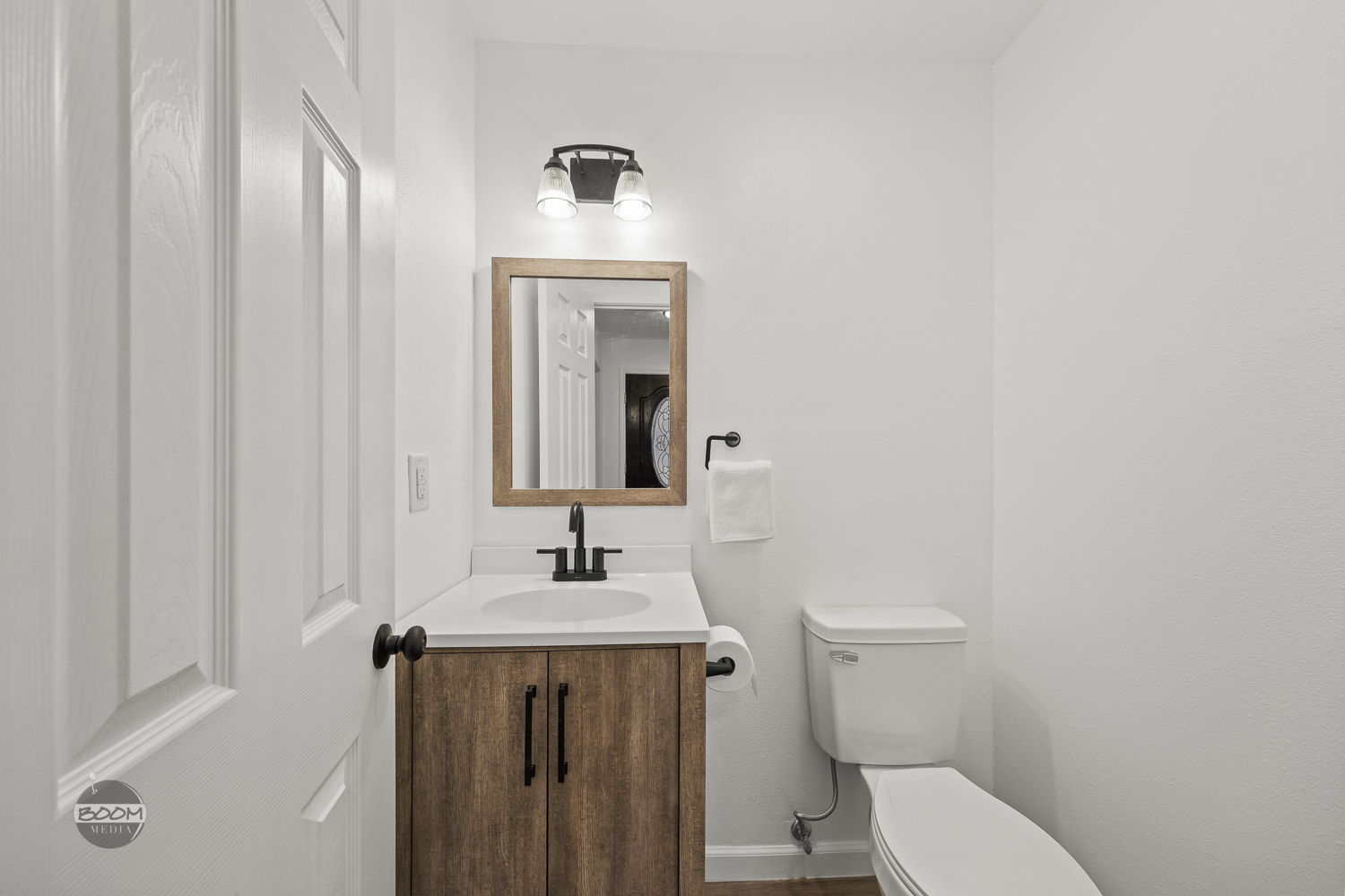 Half bath with a wood vanity and matte black fixtures